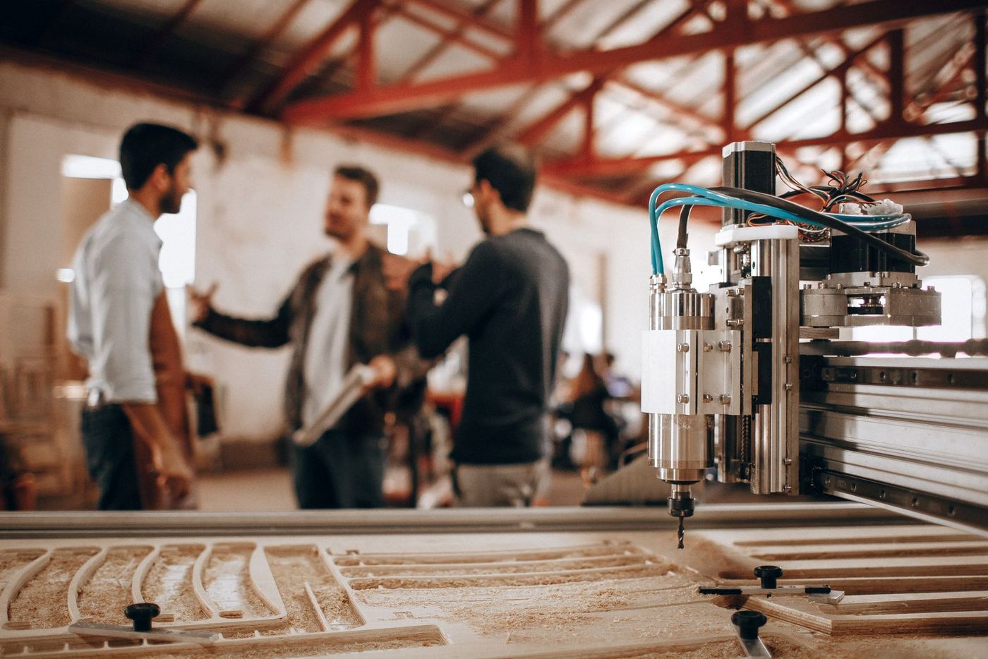 Team discussing a CNC machining job in a bright workshop