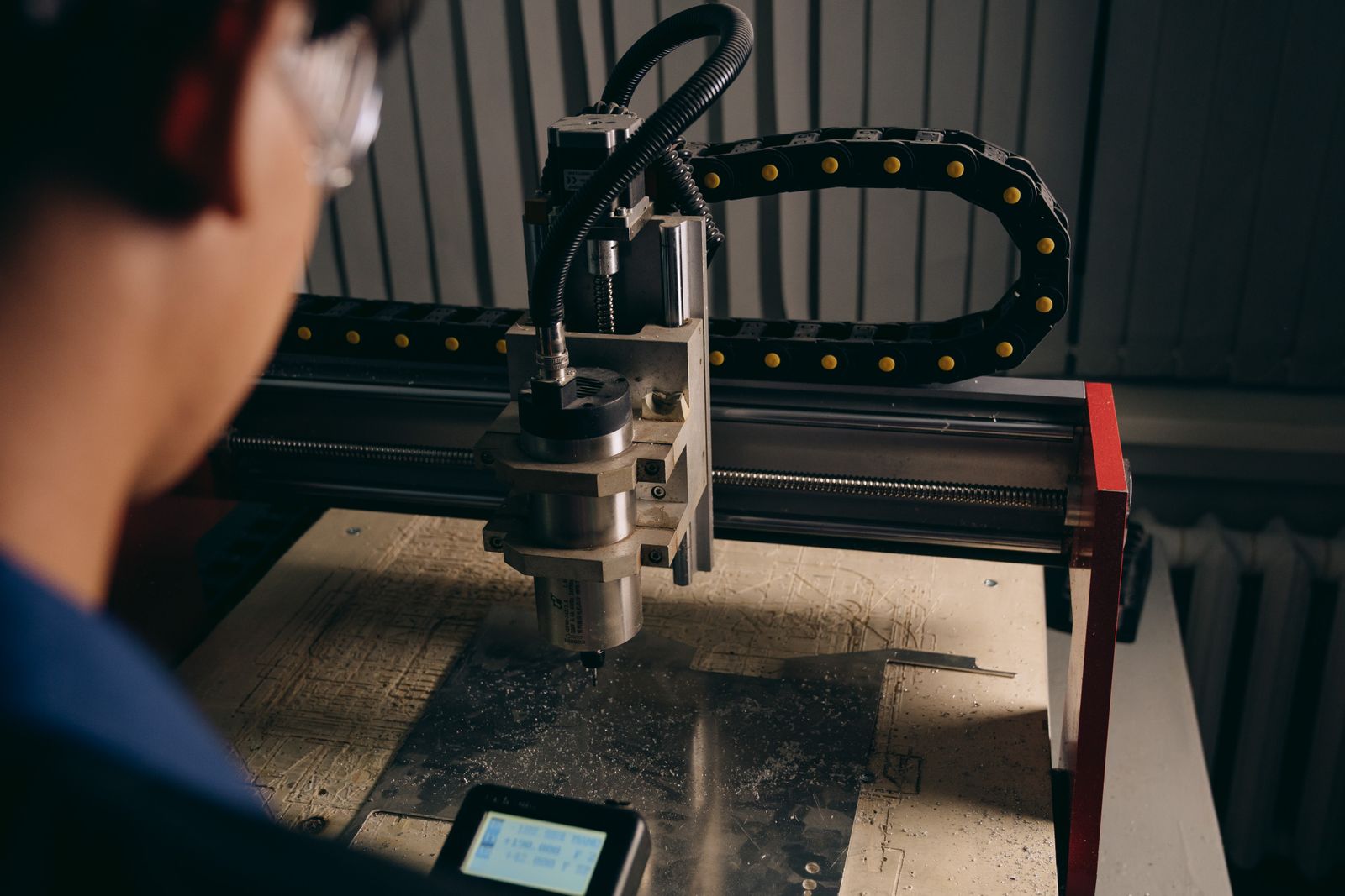 Machine operator monitoring a CNC router in a real workshop